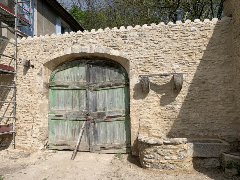 Portail en bois sous arche de pierre restaurée